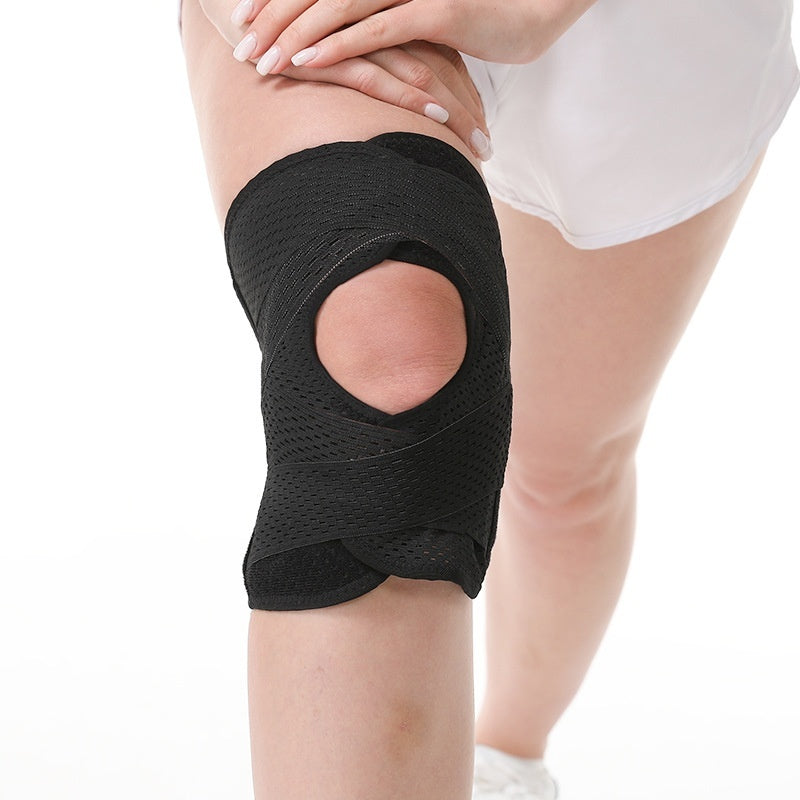 A black knee support brace with a large cutout on the front, shown worn on a person's knee against a white background.