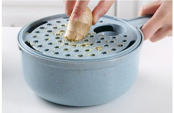Hands grating fresh ginger using the grater attachment